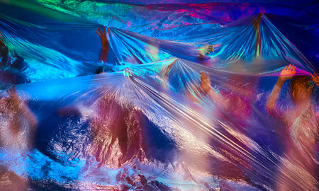 Talented dancers in pink leotards perform gracefully on stage behind a transparent curtain lit with...
