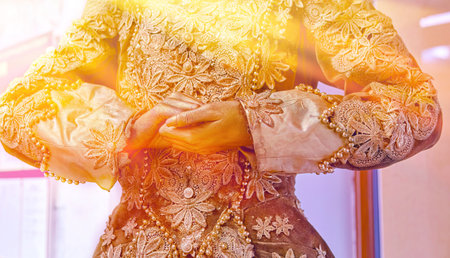 A stunning close-up of an intricately designed garment adorned with flowers and beads during a vibrant festival celebrationの写真素材