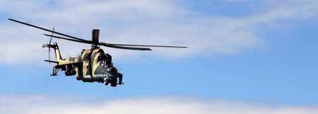 A military helicopter maneuvers through the clear blue sky, demonstrating its capabilities and...