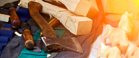 A small group of carved wooden animals stands on a workbench, emerging from the chaos of a...