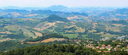 A sweeping vista showcasing the lush greenery and agricultural fields of Italy, framed by majestic...