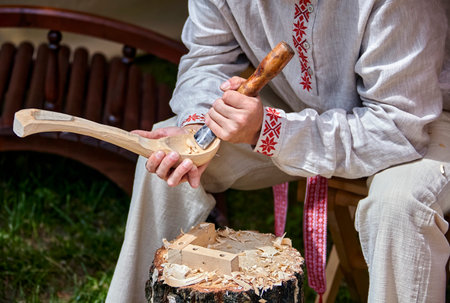A Craftsmans Delicate Touch: Carving a Wooden Bowl in the Warm Light of a Workshopの写真素材