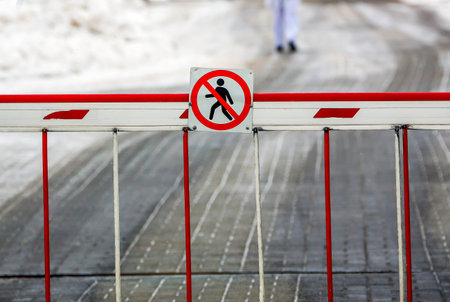 No entry signals caution at a snowy pathway during the quiet winter afternoon
