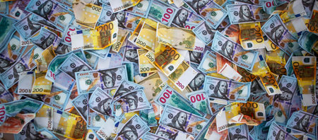 A diverse collection of banknotes is scattered across a flat surface, featuring various...