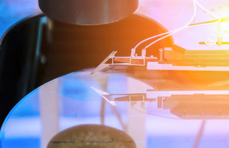 High-tech equipment takes precise measurements on a silicon wafer in a cleanroom, ensuring quality in semiconductor production.の写真素材