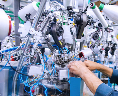 Workers focus on assembling complex machinery components in a high-tech production environment filled with advanced tools.の写真素材