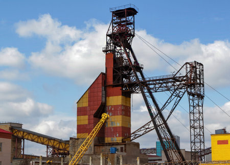 A prominent industrial site features a tall, colorful structure with machinery and equipment against...