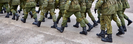 Troops are marching in unison on a city street, showcasing military discipline and readiness during a drill in sunny weather.の写真素材