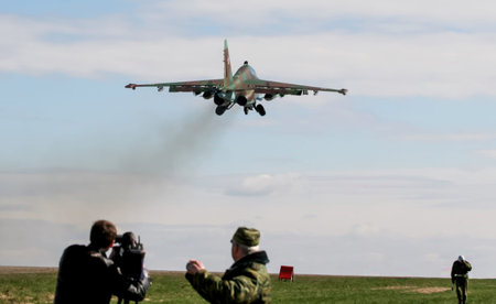 Military exercises in Belarus display aircraft taking off with smoke trailing behind. Soldiers...