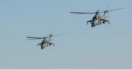 Two military helicopters participate in training exercises over the open skies of Belarus. The drills showcase flight maneuvers and coordination skills relevant to defense operations.の写真素材