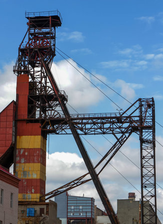 An impressive old industrial structure stands tall against a vivid blue sky in a historic mining...