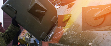 Soldiers perform maintenance on an armored vehicle in a snowy area, ensuring readiness and functionality during winter operations.の写真素材