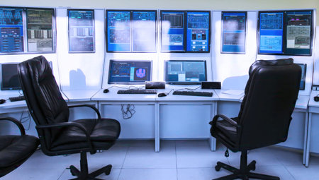 Control room with multiple screens for monitoring tasks and data analysis during working hours in a modern workplace setupの写真素材