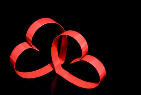 Two hearts with center spot light, on black  background.の写真素材