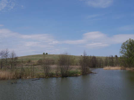 spring river in cloudy weather. Green grassの写真素材