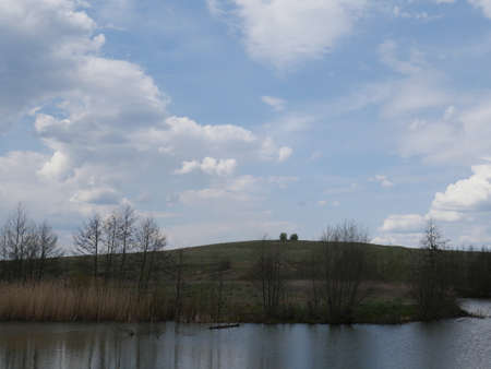 spring river in cloudy weather. Green grassの写真素材