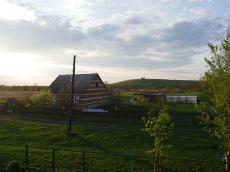 Village house on a Sunny evening. Summer and lots of green grassの写真素材