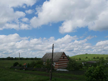 Rural landscape with house. Summertime. Blue sky and white clouds.の写真素材