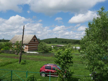 Rural landscape with house. Summertime. Blue sky and white clouds.の写真素材