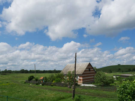 Rural landscape with house. Summertime. Blue sky and white clouds.の写真素材