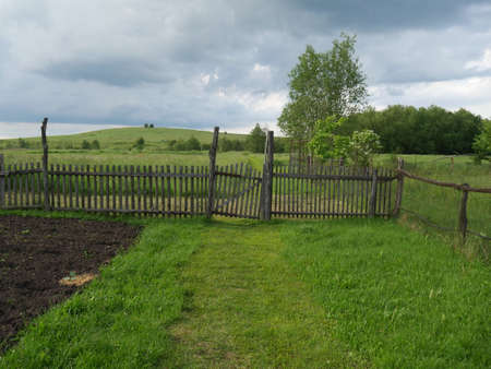 Rural landscape. Wooden fence. Lots of green grass and trees. Summer.の写真素材