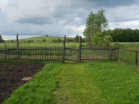 Rural landscape. Wooden fence. Lots of green grass and trees. Summer.の写真素材