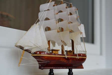 Small model of a sea vessel with sails. On white background.の写真素材