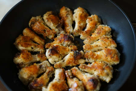 Fried chicken wings. Golden color. In a pan.の写真素材