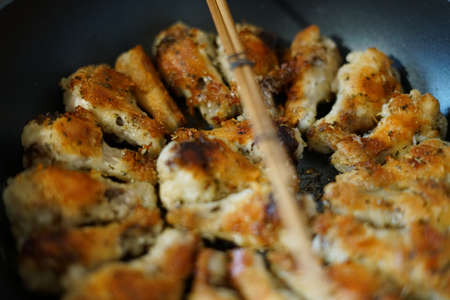 Fried chicken wings. Golden color. In a pan.の写真素材