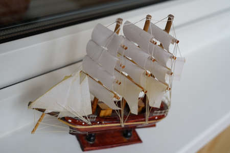 Small model of a sea vessel with sails. On white background.の写真素材