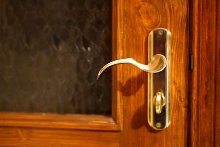 A closed wooden door and a gold handle. Home refined interior.の写真素材