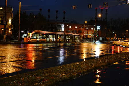 Moscow, Russia November 11 2020: Night view of the streets of Moscow. The tram arrives at the station. An intersection with a traffic light. Night lights and cars. Motor road. Autumnのeditorial素材