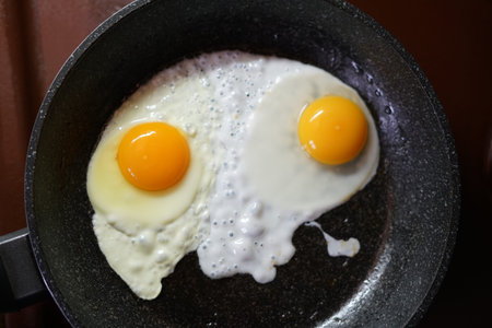 Fried eggs in a frying pan. Yellow yolks. The view from the top.の写真素材