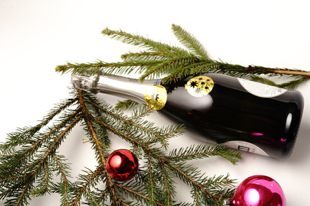 Bottle of champagne and a Christmas tree branch. Christmas toy. On white background. Isolateの写真素材