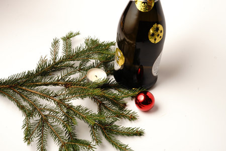 Bottle of champagne and a Christmas tree branch. Christmas toy. On white background. Isolateの写真素材