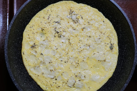 Scrambled eggs in a frying pan with spices for Breakfast.