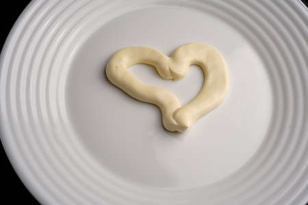Cream heart edible on a white plate top view. Close.の写真素材