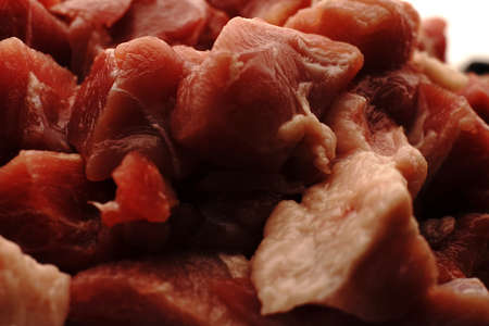 Raw pieces of red pork meat closeup. Finely chopped for cooking.の写真素材