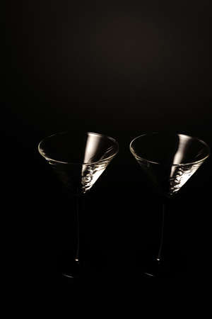 Two empty cocktail glasses on a black background. Studio shooting.の写真素材