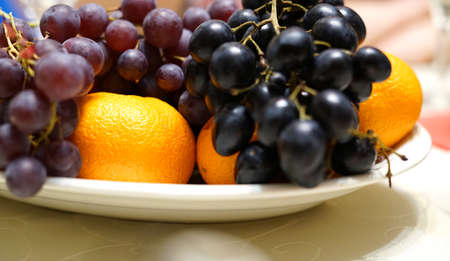 Fruit on the festive table. The two types of grapes and tangerines.の写真素材