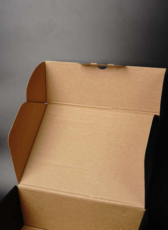 An open cardboard box on a black background. Dimmed lightsの写真素材