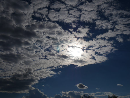Dark blue sky and dark clouds and the sun breaking through. Dark and dramatic