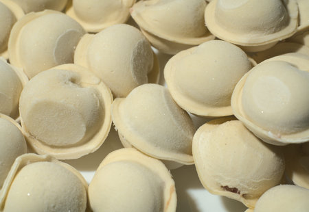 Raw frozen dumplings. Closeup. Frost is visible on the dumplings