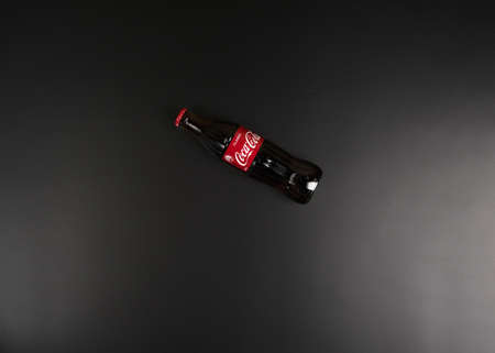 Moscow, Russia - may 20 2021: Glass bottle of Coca-Cola on a black background. Flat layのeditorial素材