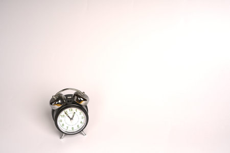 Black and white analog alarm clock on a white background. Retro style. Space for text