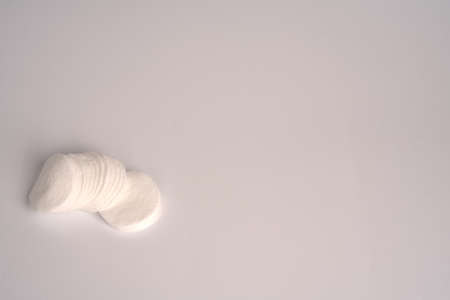 Cotton pads for removing makeup and spa treatments on a white background. Closeup. Space for the textの写真素材