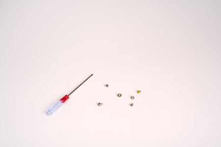 A small screwdriver and small screws on a white background.の写真素材