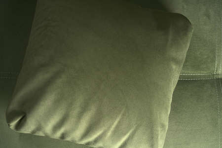Top view of a green pillow lying on a soft sofa.の写真素材