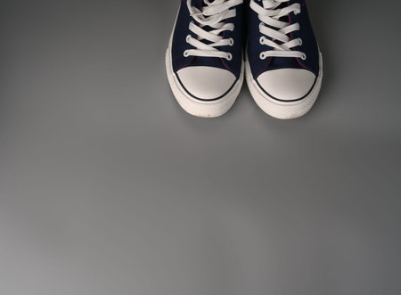 White and blue sneakers on a gray background.