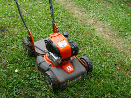 Moscow, Russia - june 20 2020: The orange branded lawn mower stands on the green grass in summerのeditorial素材